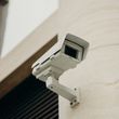 A silhouette of a security camera on a white background.